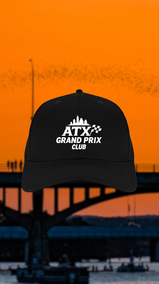 Black cap with 'ATX Grand Prix Club' logo against an orange sunset Austin background